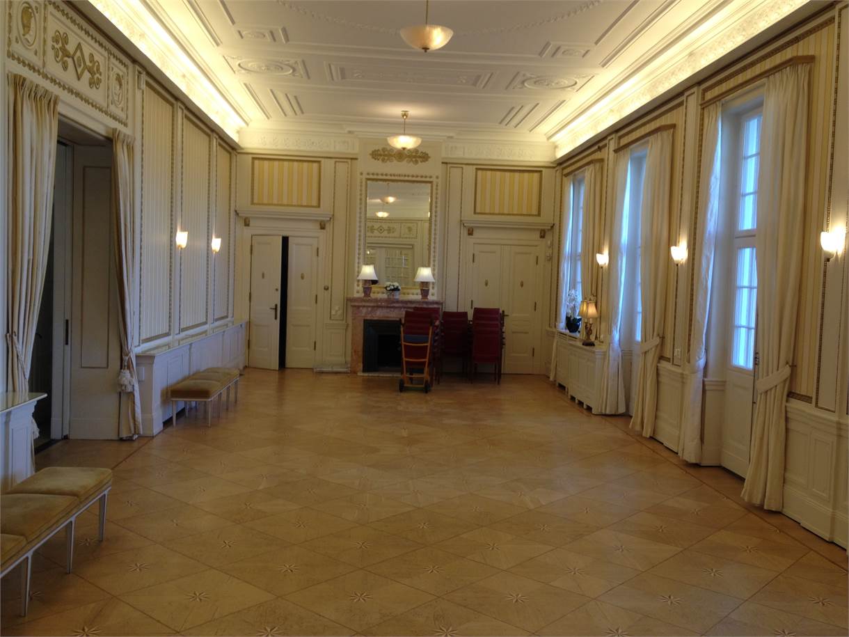 A restored salon at Fridhemsborg with coffered ceiling, marble fireplace and parquet floor